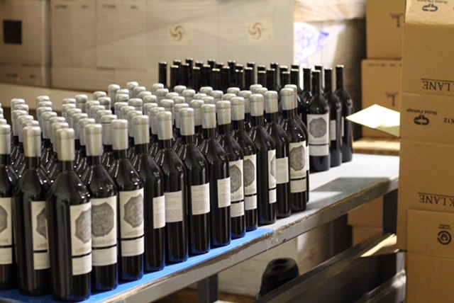 Many wine bottles on a conveyor belt