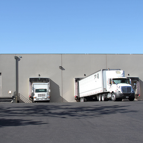 Trucks loading in back of warehouse