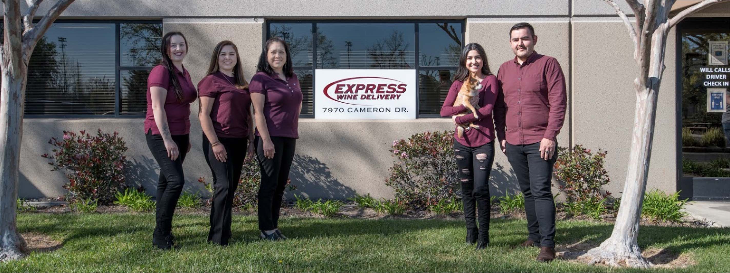 Staff members posing in front of Express Wine Delivery building